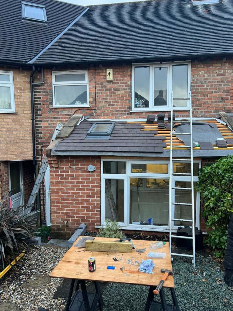 This is a photo of a roof extension that is having new roof tiles installed. This is a photo taken from the roof ridge looking down a tiled pitched roof on to a flat roof. Works carried out by Westerham Roofing Repairs